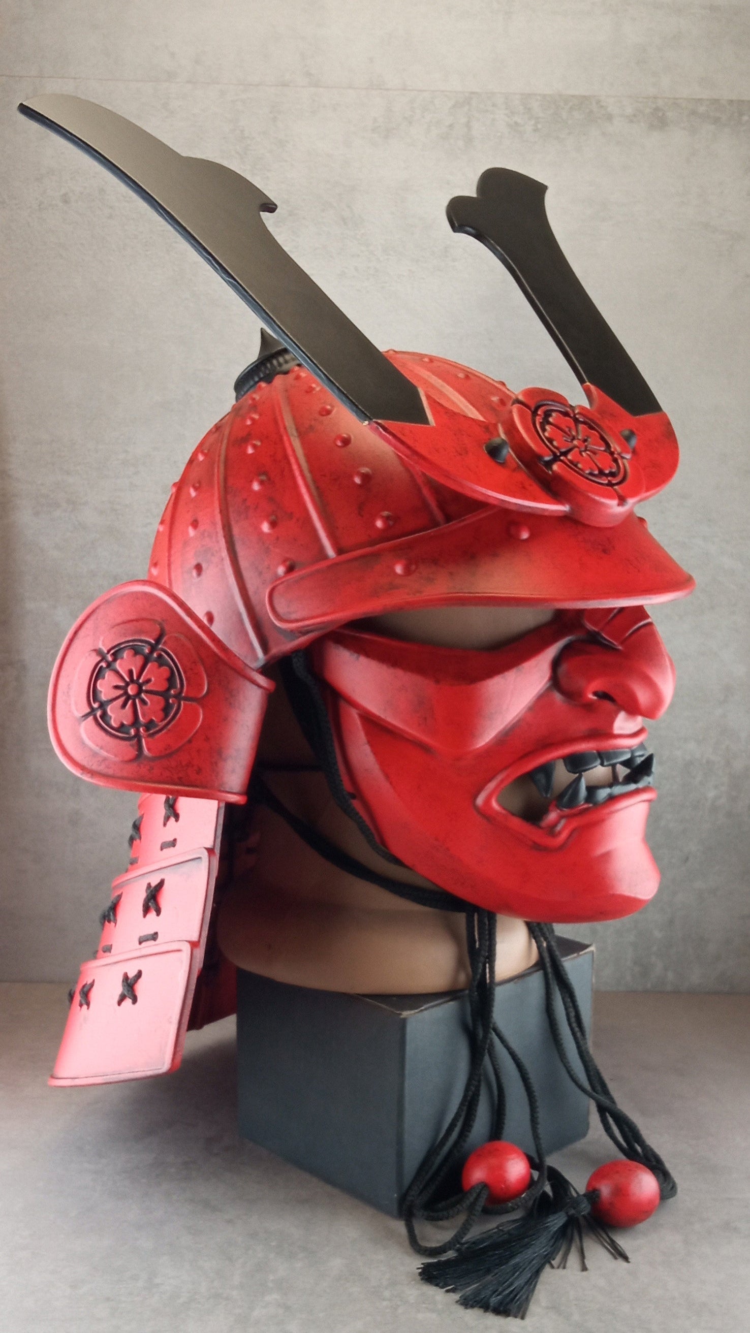 Red samurai helmet with face mask on a gray background
