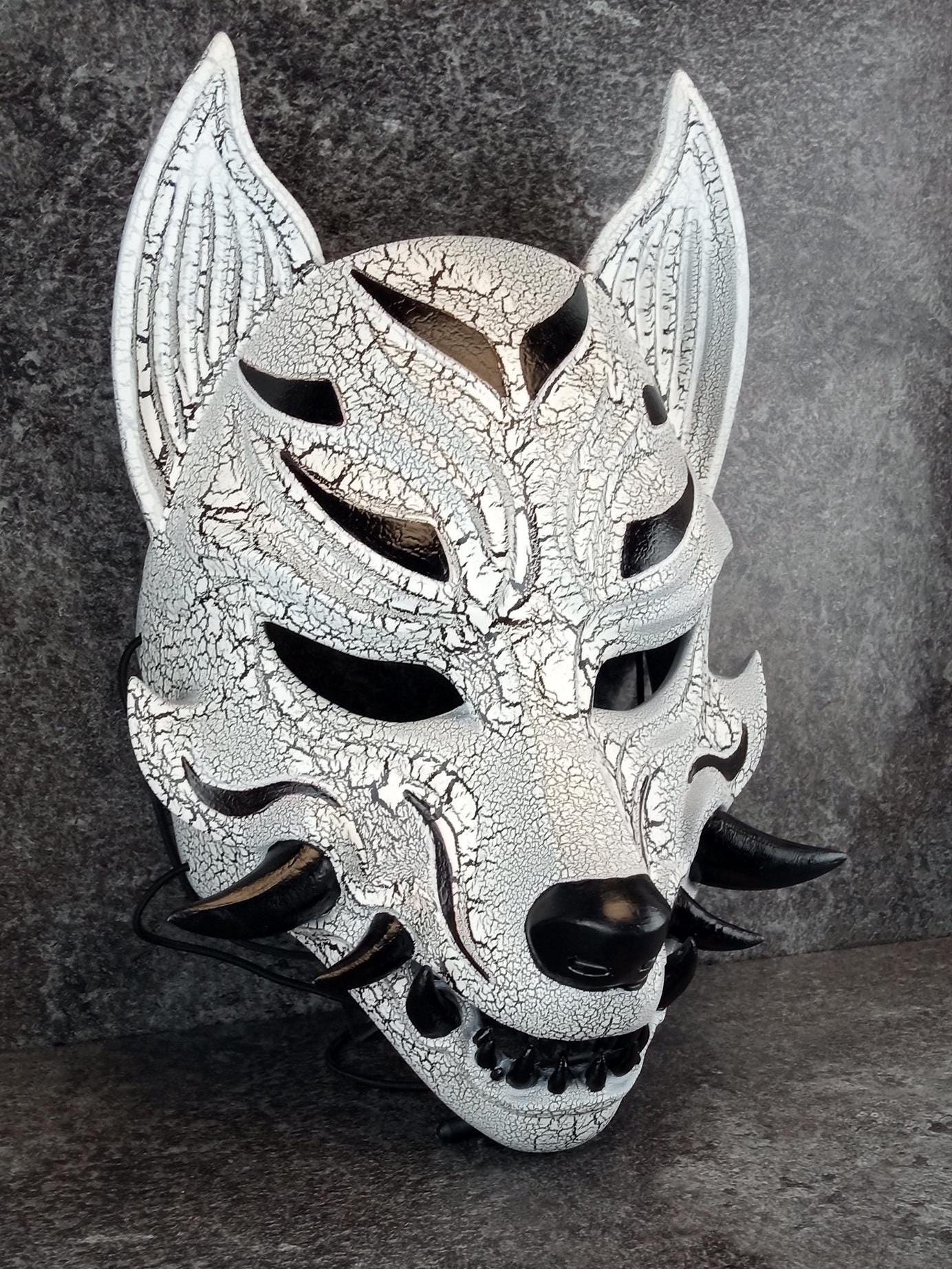 Schwarz-weiße rissige Kitsune (Okami)-Maske mit schwarzen Reißzähnen