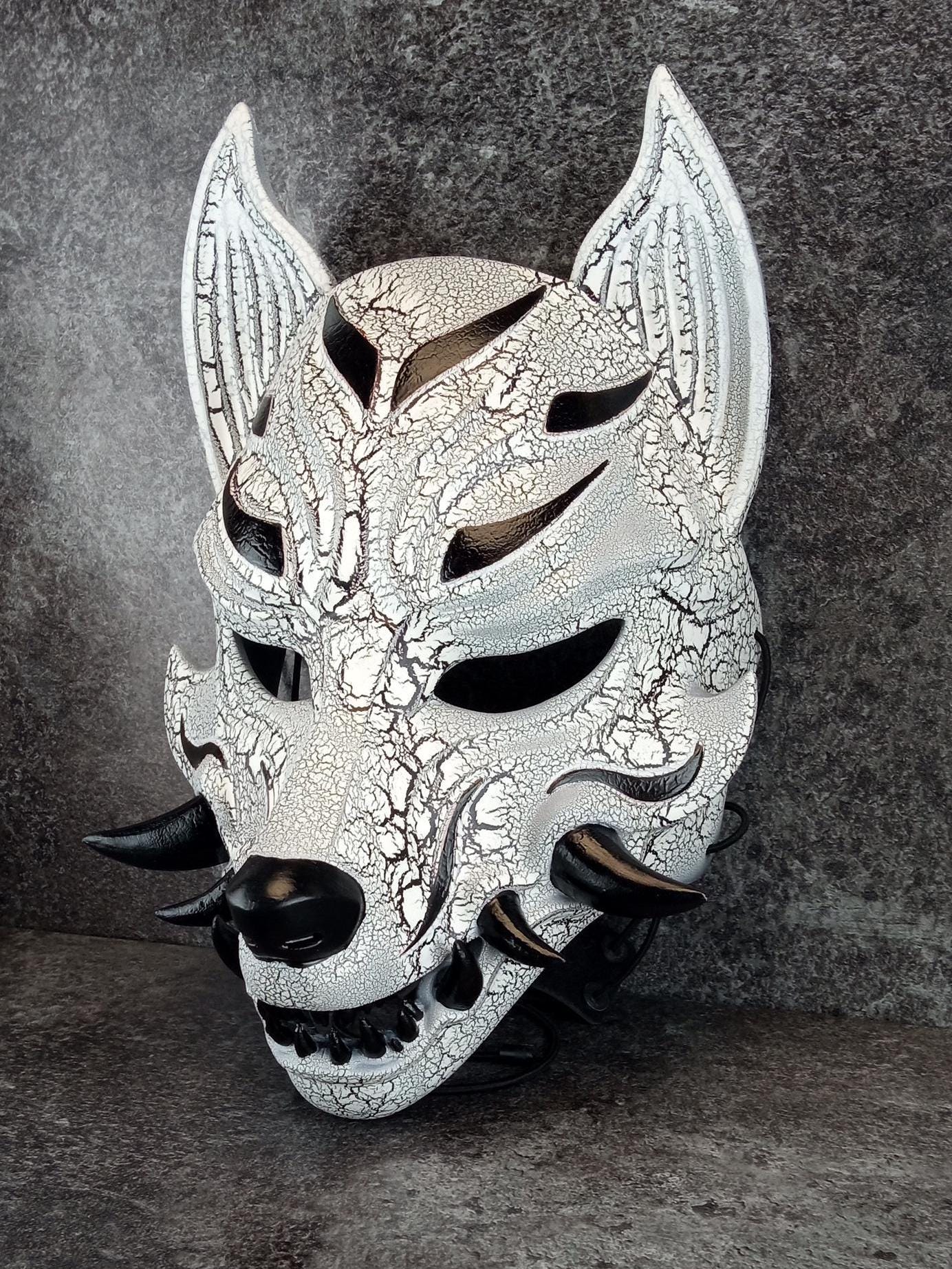 Schwarz-weiße rissige Kitsune (Okami)-Maske mit schwarzen Reißzähnen