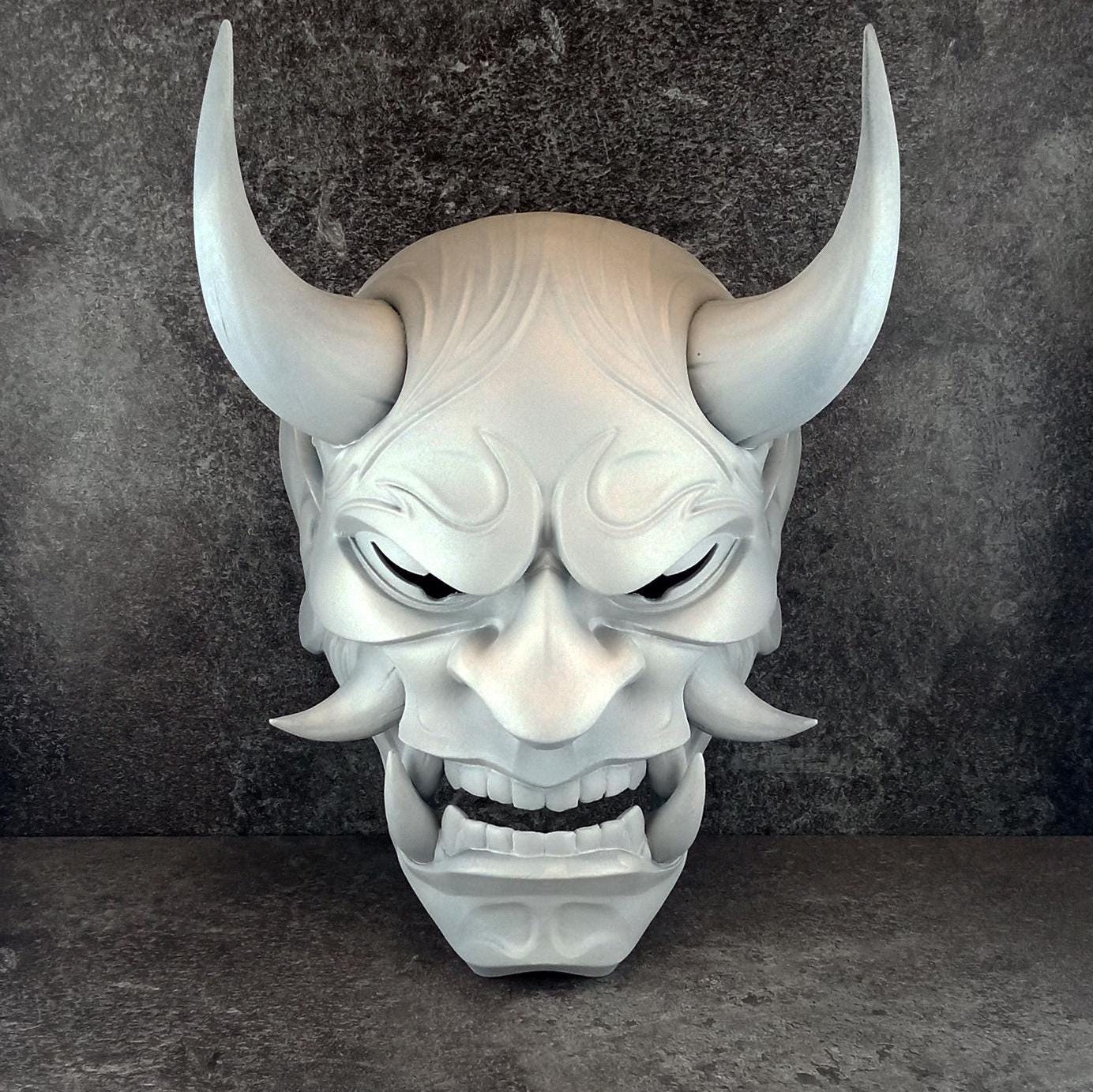 Schwarze und goldene rissige traditionelle Hannya-Maske mit großen schwarzen Augenbrauen