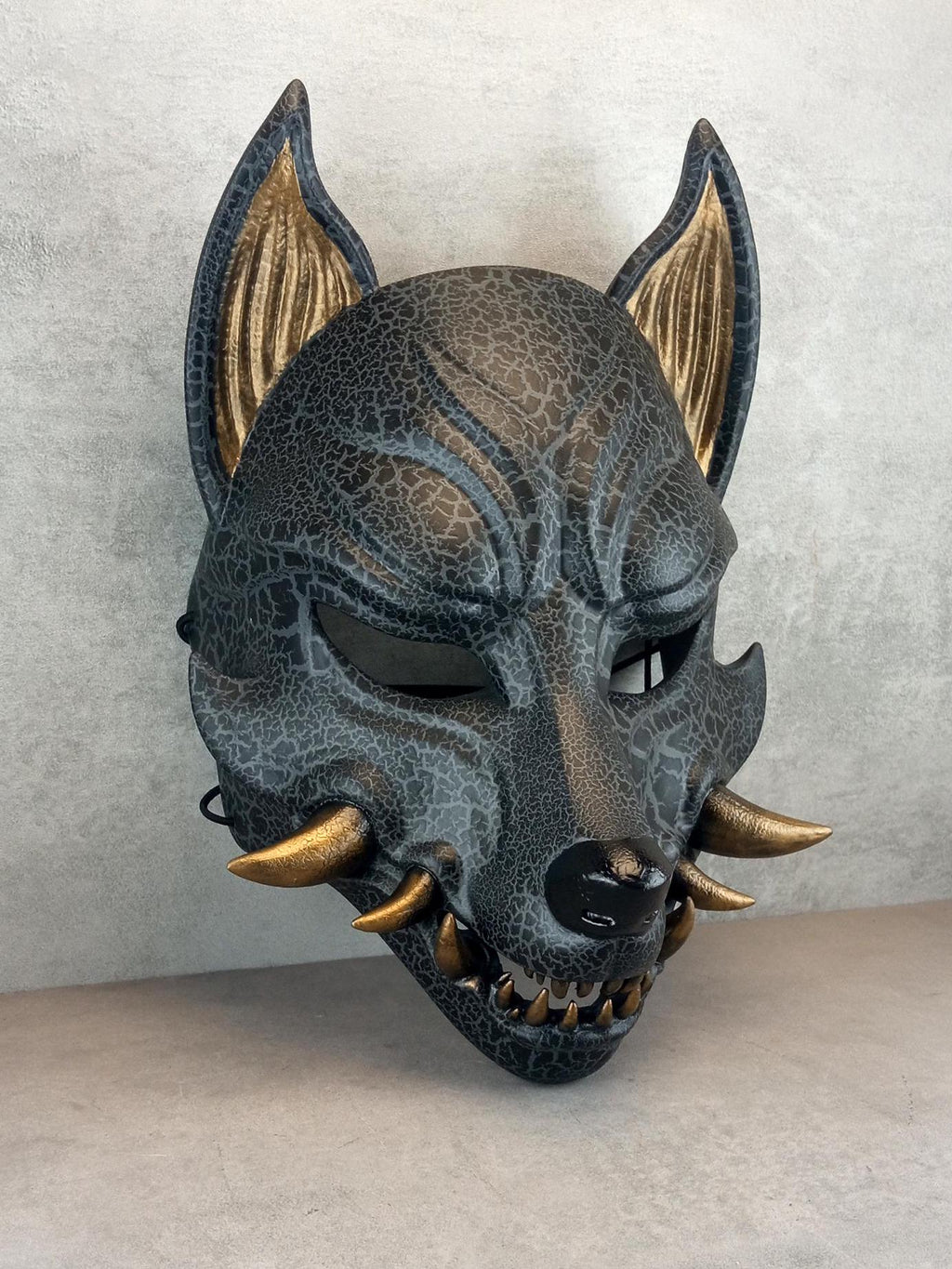 Rissige graue Kitsune (Okami)-Maske mit bronzenen Reißzähnen