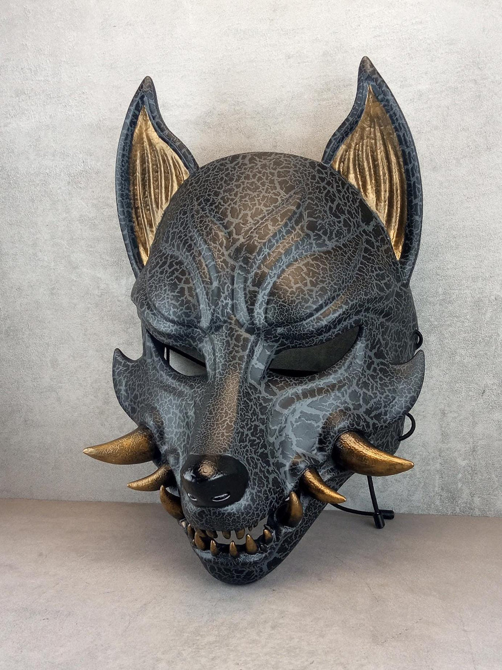 Rissige graue Kitsune (Okami)-Maske mit bronzenen Reißzähnen