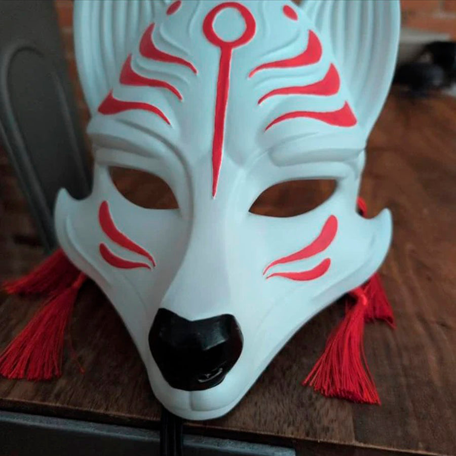 Schwarz-weiße rissige Kitsune (Okami)-Maske mit schwarzen Reißzähnen