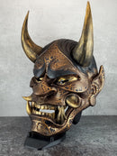 Schwarze und goldene rissige traditionelle Hannya-Maske mit großen schwarzen Augenbrauen