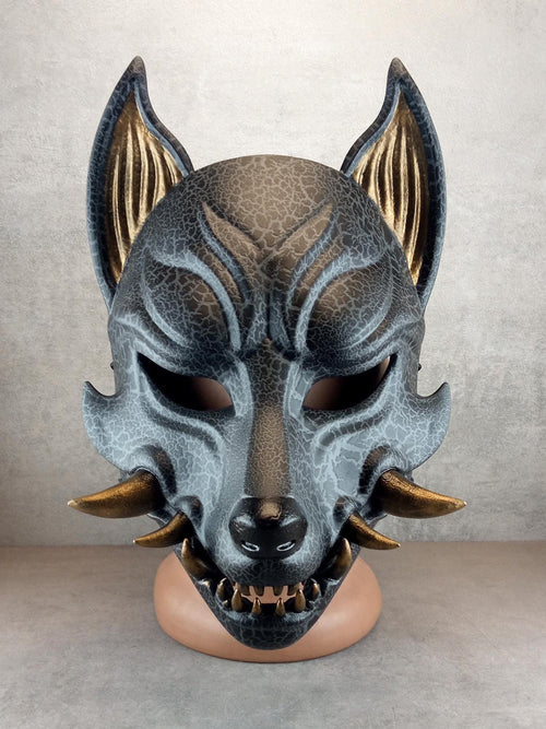 Rissige graue Kitsune (Okami)-Maske mit bronzenen Reißzähnen