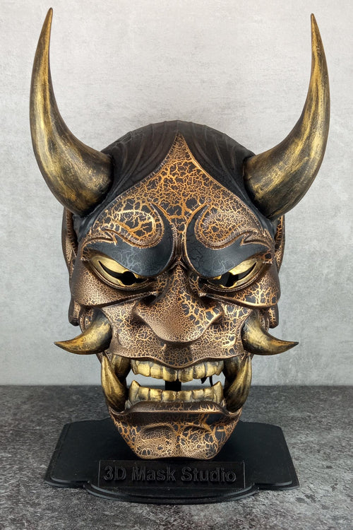 Schwarze und goldene rissige traditionelle Hannya-Maske mit großen schwarzen Augenbrauen