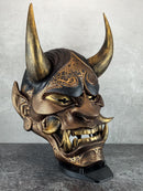 Schwarze und goldene rissige traditionelle Hannya-Maske mit großen schwarzen Augenbrauen