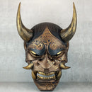 Schwarze und goldene rissige traditionelle Hannya-Maske mit großen schwarzen Augenbrauen