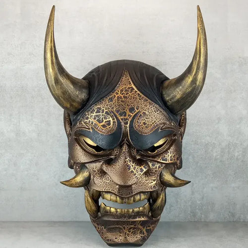 Schwarze und goldene rissige traditionelle Hannya-Maske mit großen schwarzen Augenbrauen