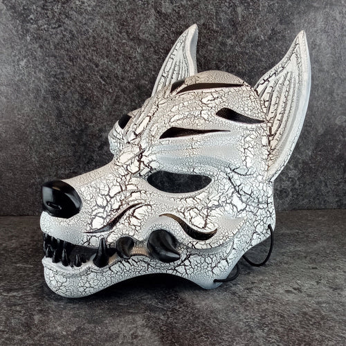 Schwarz-weiße rissige Kitsune (Okami)-Maske mit schwarzen Reißzähnen