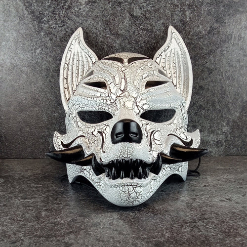 Schwarz-weiße rissige Kitsune (Okami)-Maske mit schwarzen Reißzähnen