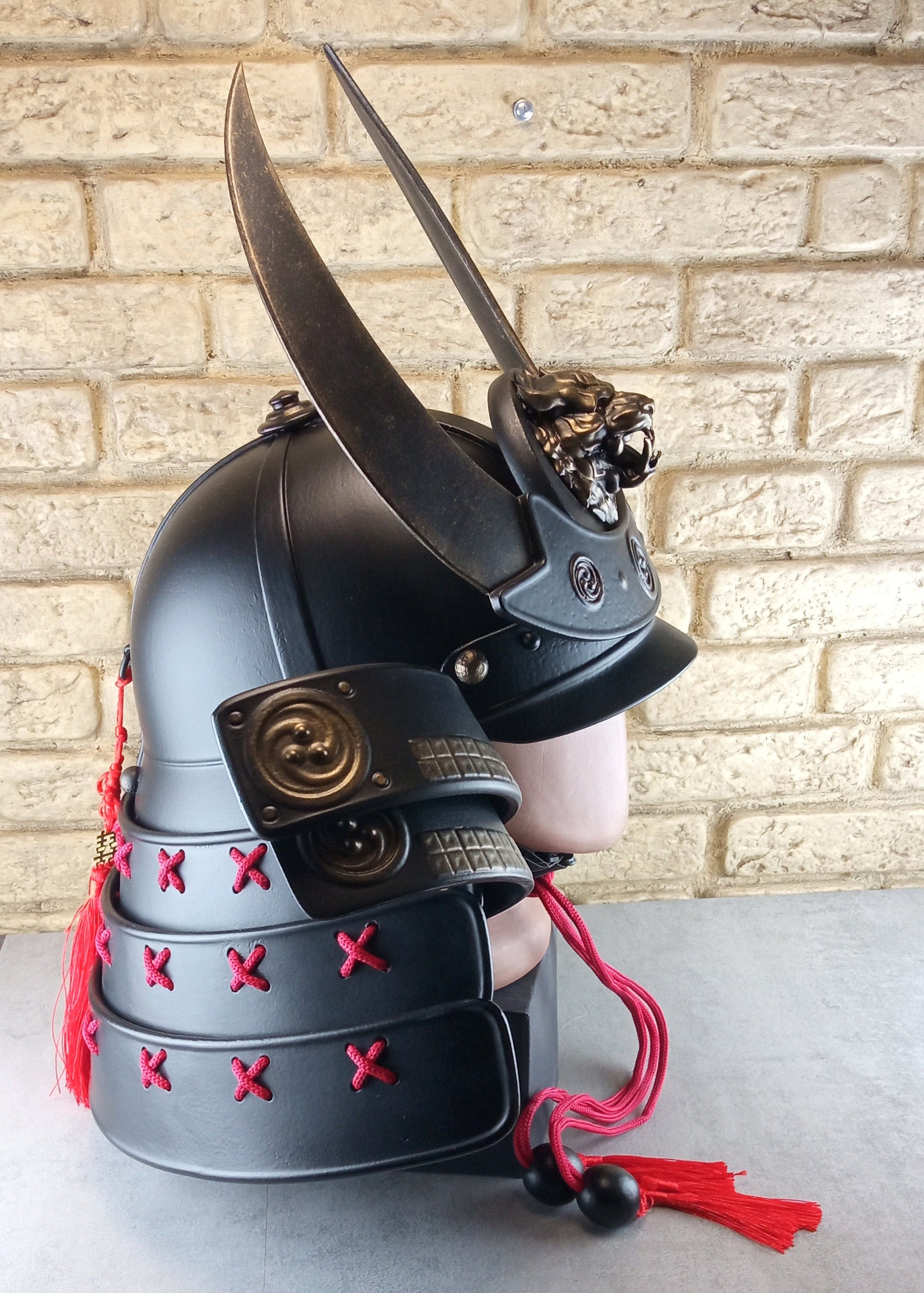Schwarzer Samurai-Kabuto-Helm mit bronzenen Akzenten und zentralem Oni-Tiger-Emblem