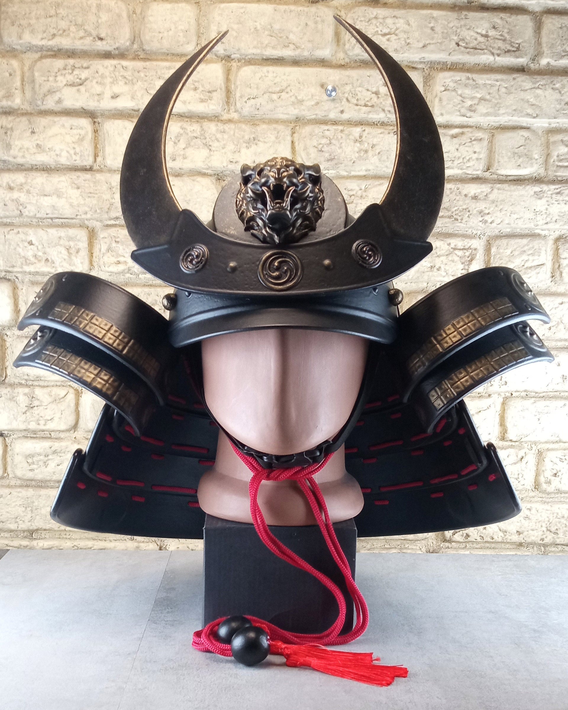 Schwarzer Samurai-Kabuto-Helm mit bronzenen Akzenten und zentralem Oni-Tiger-Emblem