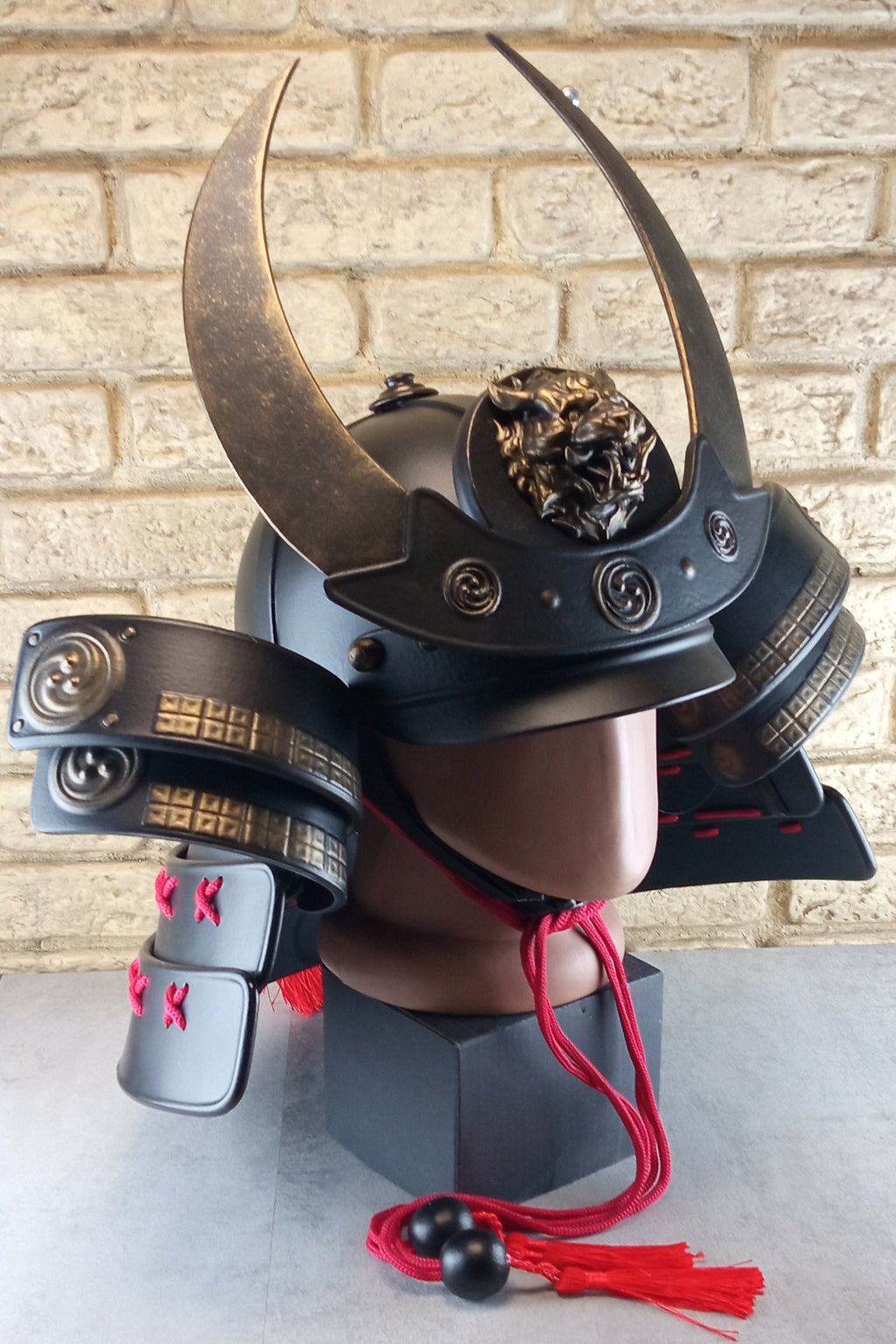 Schwarzer Samurai-Kabuto-Helm mit bronzenen Akzenten und zentralem Oni-Tiger-Emblem