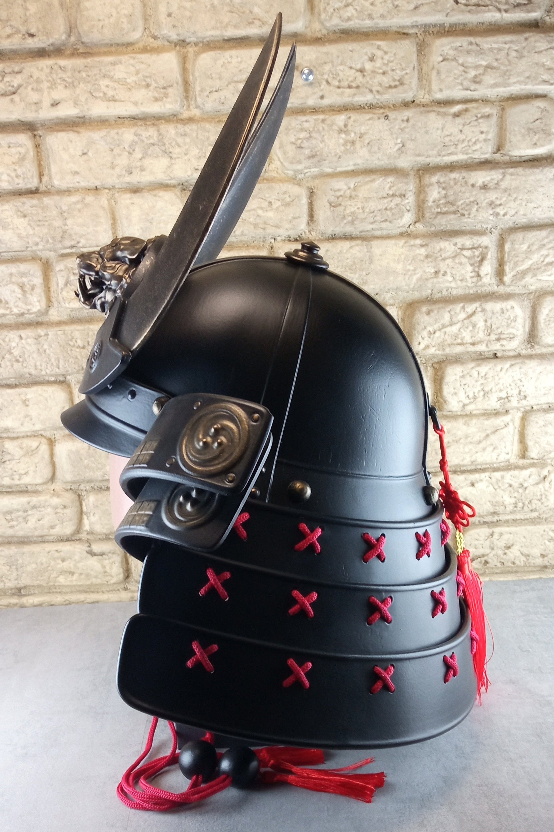 Schwarzer Samurai-Kabuto-Helm mit bronzenen Akzenten und zentralem Oni-Tiger-Emblem
