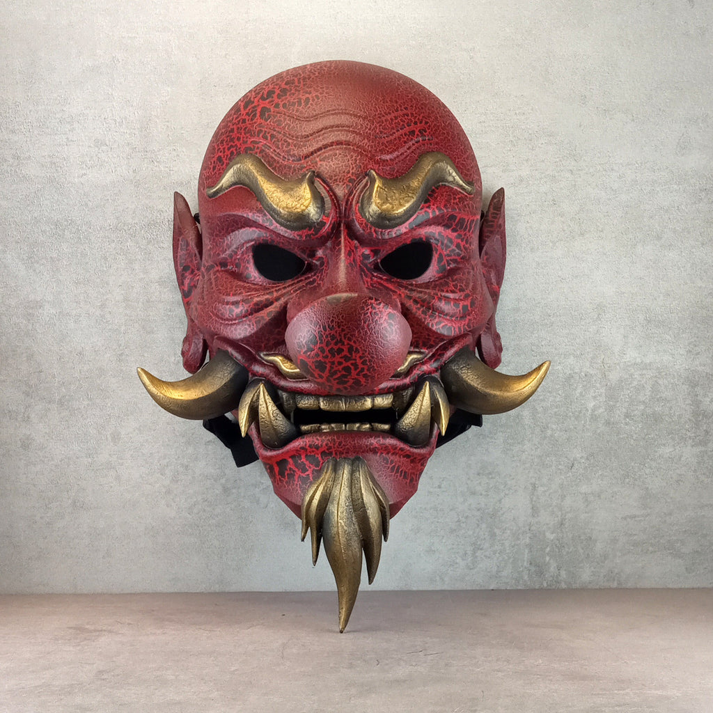 Rote, gesprungene Tengu-Dämonenmaske mit goldenen Reißzähnen
