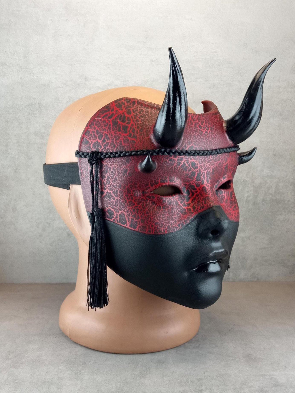 Rot-schwarze Geisha-Hexenmaske mit Rissen und glänzenden schwarzen Hörnern