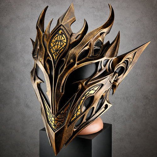 A highly detailed fantasy mask with sharp, flame-like metallic spikes and intricate cutouts, finished in a bronze-gold color with black recessed areas and small gold accents. The mask is displayed on a black pedestal against a textured gray studio background.