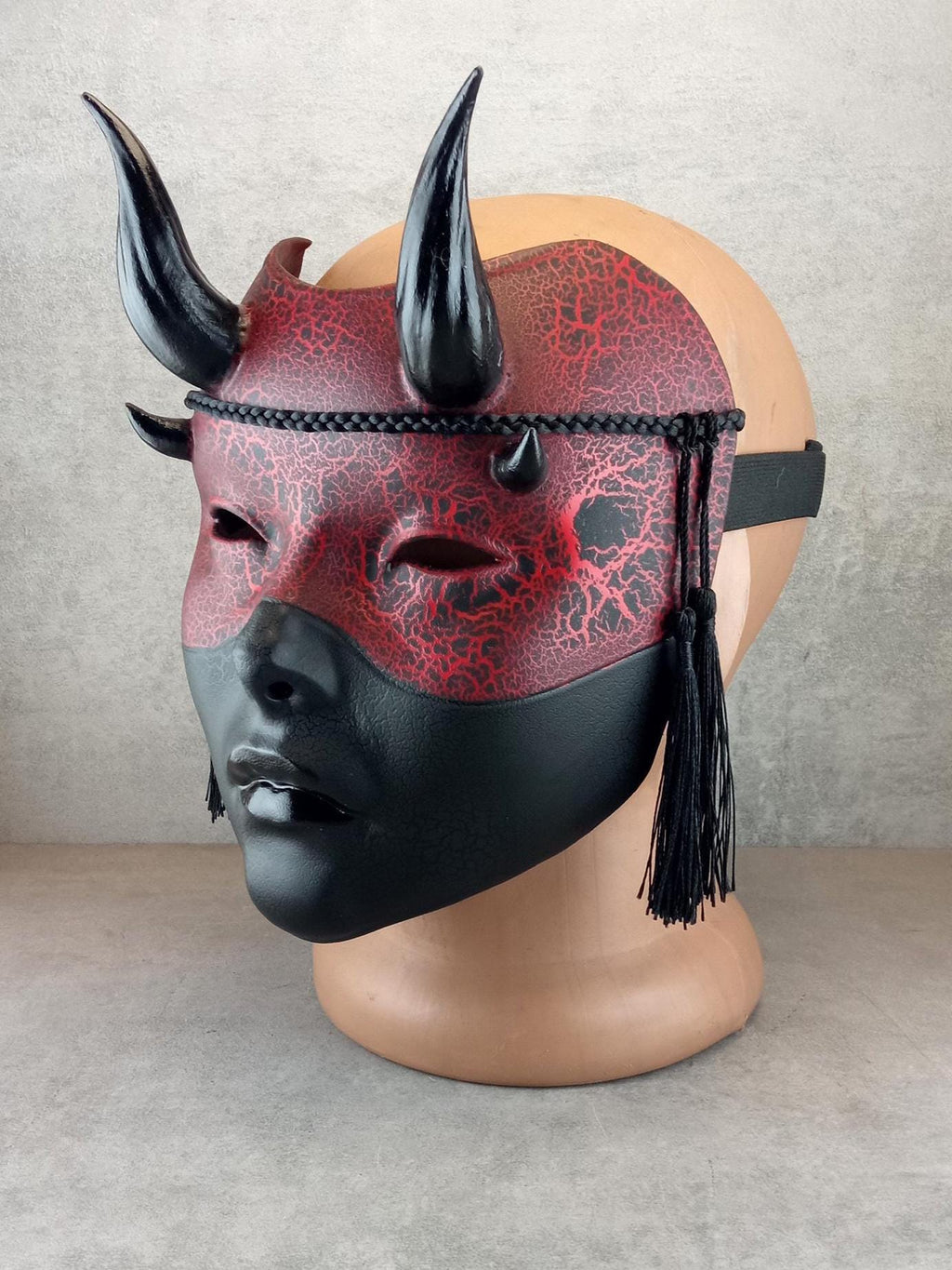 Rot-schwarze Geisha-Hexenmaske mit Rissen und glänzenden schwarzen Hörnern