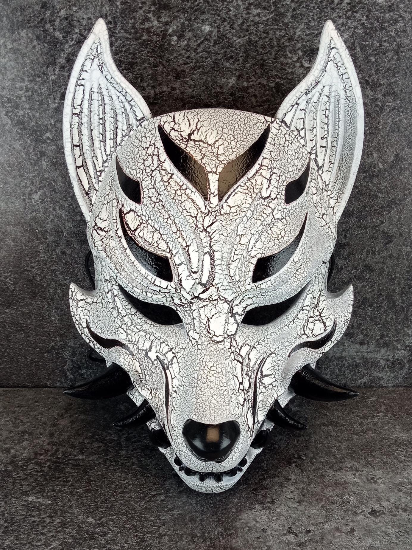 Schwarz-weiße rissige Kitsune (Okami)-Maske mit schwarzen Reißzähnen