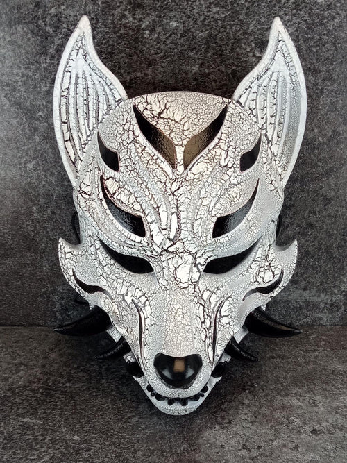 Schwarz-weiße rissige Kitsune (Okami)-Maske mit schwarzen Reißzähnen