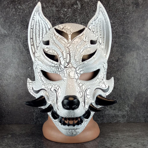 Schwarz-weiße rissige Kitsune (Okami)-Maske mit schwarzen Reißzähnen