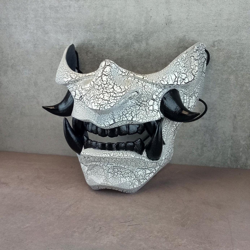 Schwarz-weiße rissige Samurai-Maske mit schwarzen Reißzähnen