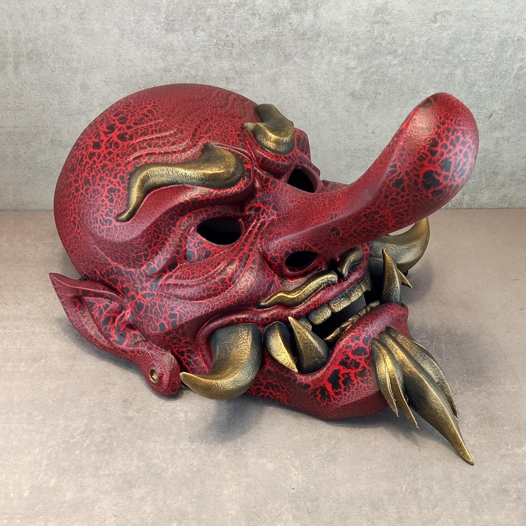 Rote, gesprungene Tengu-Dämonenmaske mit goldenen Reißzähnen