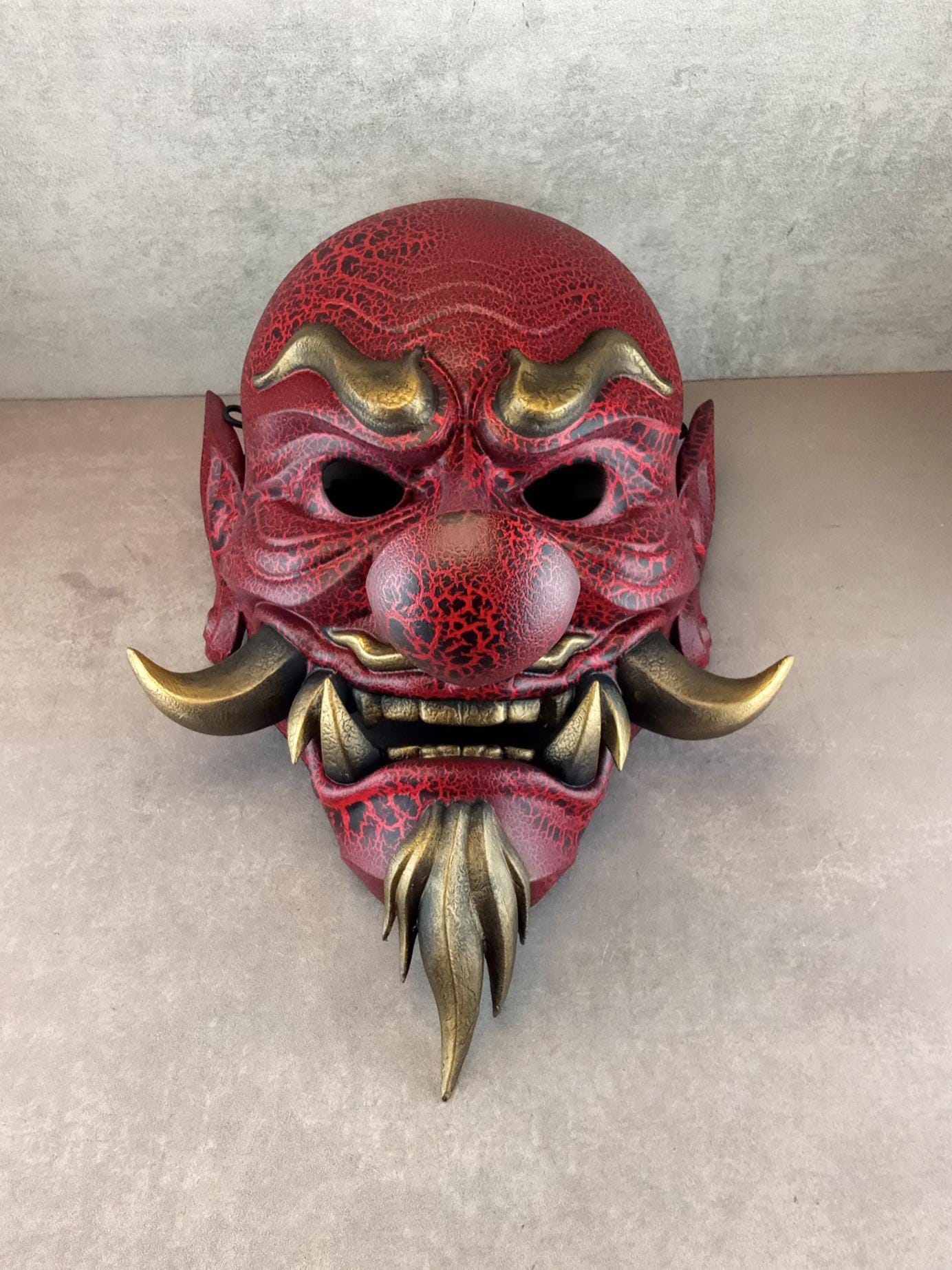 Rote, gesprungene Tengu-Dämonenmaske mit goldenen Reißzähnen