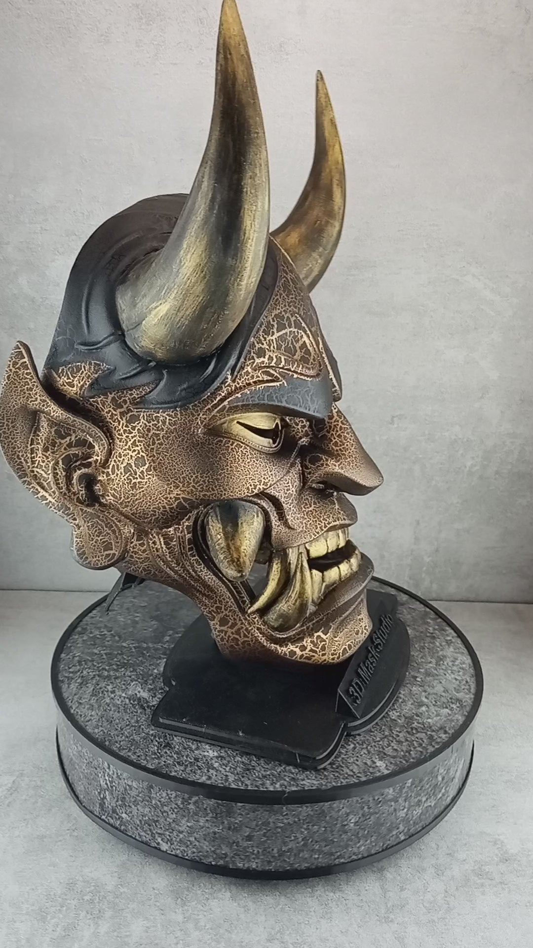 Schwarze und goldene rissige traditionelle Hannya-Maske mit großen schwarzen Augenbrauen