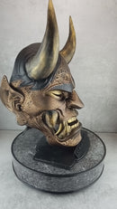 Schwarze und goldene rissige traditionelle Hannya-Maske mit großen schwarzen Augenbrauen