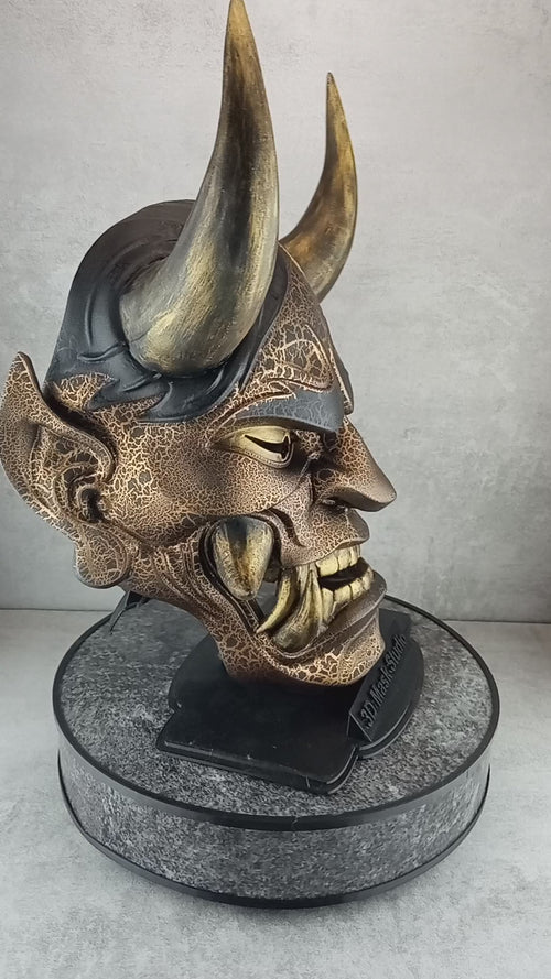 Schwarze und goldene rissige traditionelle Hannya-Maske mit großen schwarzen Augenbrauen